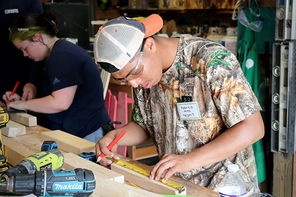 Fabricio Perez and Kyli Carroll learn carpentry skills at the 2023 Ready-to-Work Skilled Trades