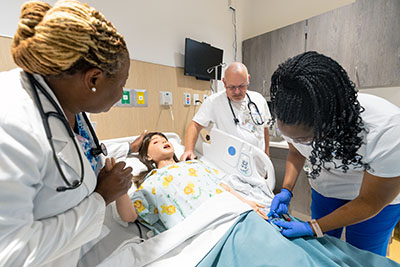 Students work with a simulated patient to hone their nursing skills.