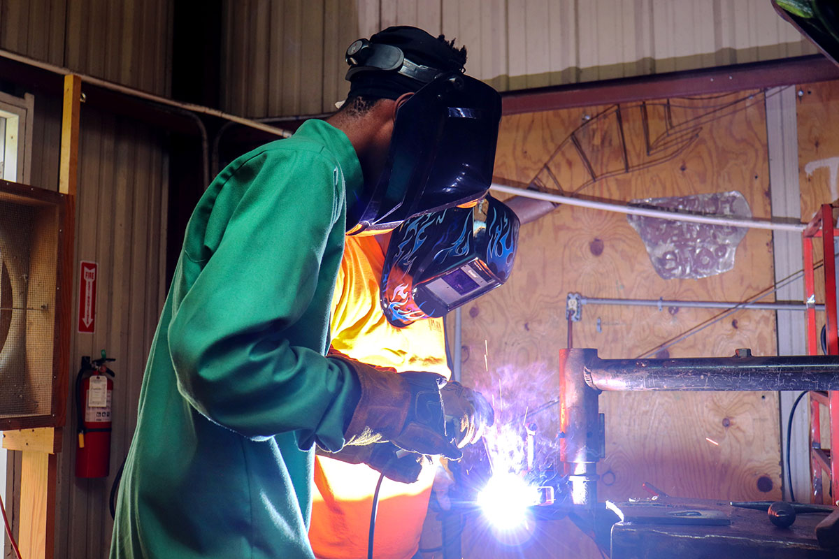 KeShawn Davis tries his hand at welding at the 2023 Ready-to-Work Skilled Trades, Marine & Manufacturing Boot Camp supervised by instructor David Bailey.  