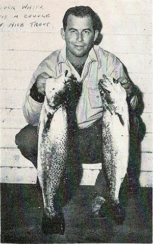 old photo of a man holding two fish